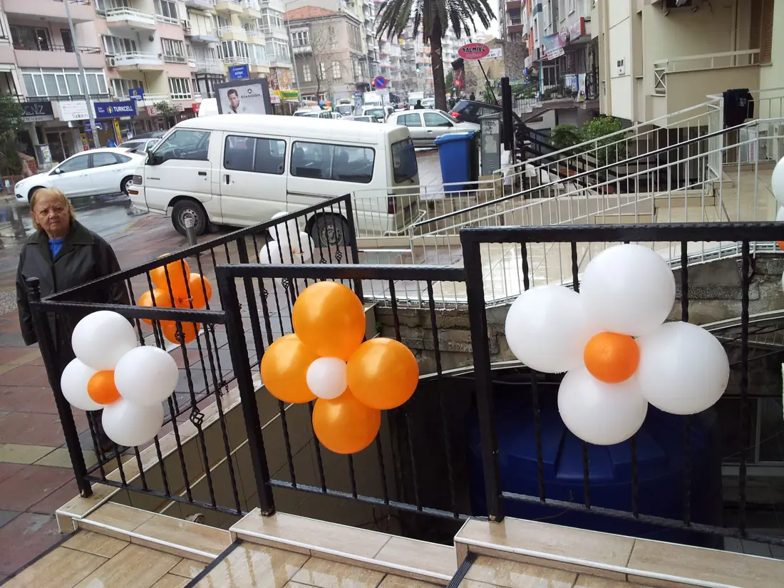 Korkuluklara bağlanmış turuncu-beyaz papatya balonlar