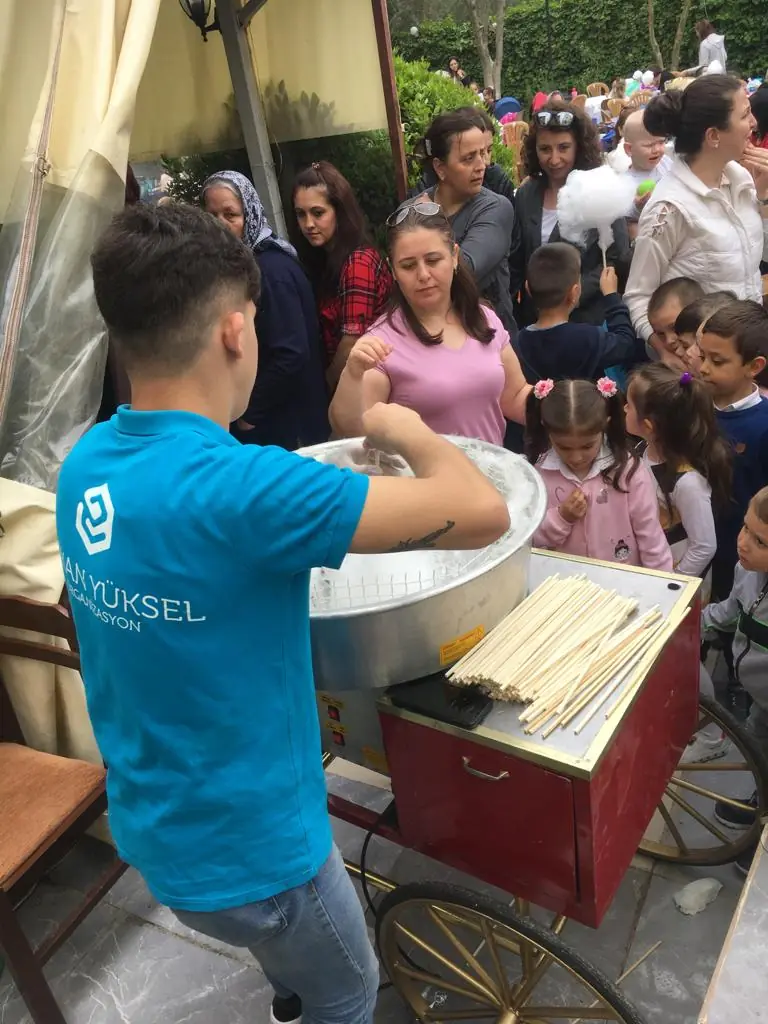 Pamuk şeker görevlisi ve çevresindeki çocuklar
