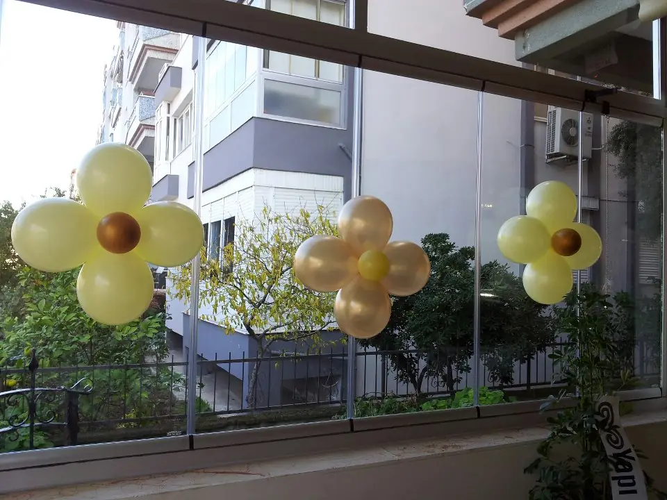 Balkon korkuluğunda sarı papatya balonlar