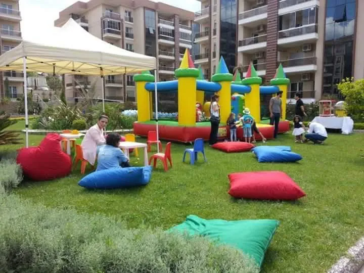 Çim alanda şişme kale ve renkli puf minderler